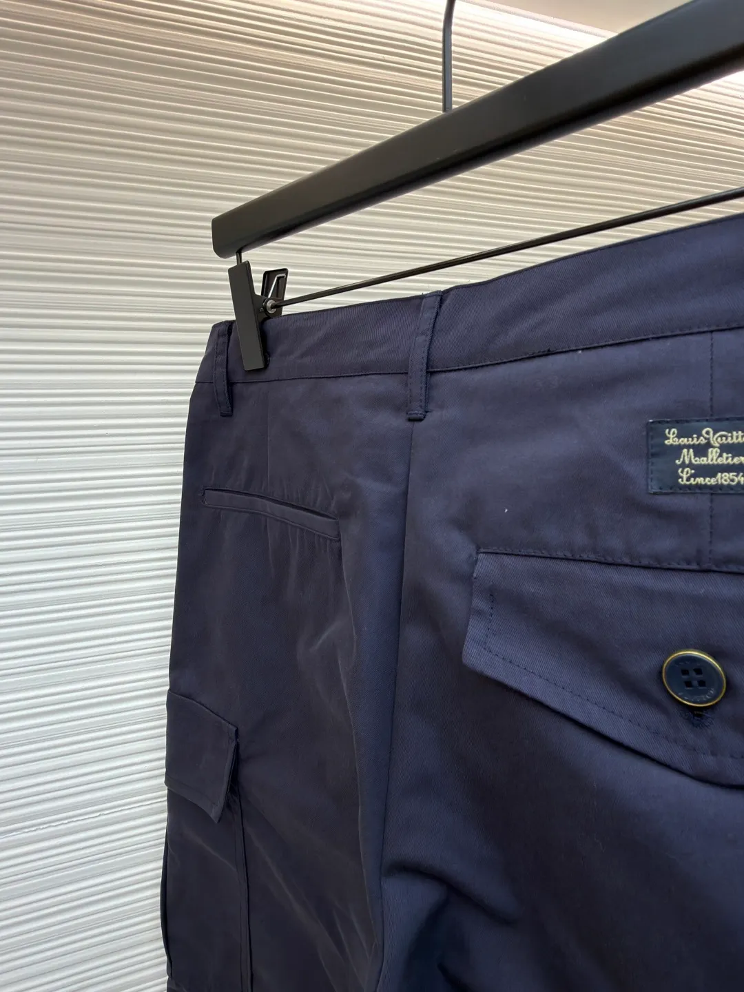 LOUIS VUITTON pocket embroidered work trousers ●Original version: Purchased and developed for 9999 ●Item number: 1681825-B50 ●Fabric: cotton twill fabric ●Technology: embroidery production ●Color: navy blue ●Version: fitted version ●Weight: about 520 grams ●Size: 44-46-48-50 ●Description: The high cotton content ensures the fabric's excellent breathability, durability and classic workwear texture, while the twill weave gives it unique wear resistance and stiffness. The special fabric technology solves the pain points of tight and stiff traditional overalls; it provides greater freedom when moving, significantly improves wearing comfort and flexibility, and achieves a balance between function and comfort. The application of three-dimensional core-spinning embroidery technology in the pocket position is achieved by adding additional cotton thread or foam as the core material to the pattern filling layer, and then using embroidery thread to fully cover the embroidery. The logo pattern is significantly protruded from the surface of the fabric, forming a full three-dimensional effect. This process not only enhances the visual impact and tactile level, but also improves the wear resistance of the pocket area through the buffering effect of the core material, ensuring that the pattern can still remain crisp and not deformed in complex daily use, ensuring that the pattern is clear and durable, and injecting a sense of sophistication into the rugged workwear style. Diversified pocket system combines workwear functionality with sophistication. The flap cargo pockets on both sides are a signature element, and their flap design prevents items from falling and enhances the visual three-dimensionality. Italian style pockets provide simple side storage. The overall wiring is straight and delicate, the fabric is comfortable and soft, and the color is consistent without color difference. It can be matched with the same style to create a fashionable look and control various occasions. Customized accessories, complete with three standards, same style for men and women!